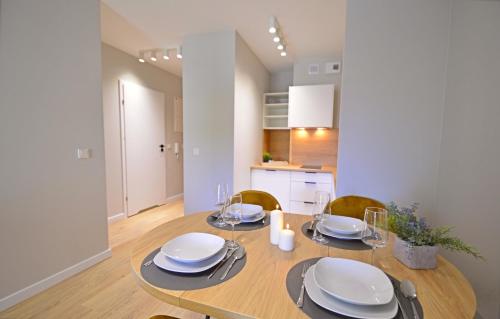 a dining room with a wooden table and chairs at Sun Towers - Apartamenty Bryza - Apartamenty z parkingiem in Świnoujście