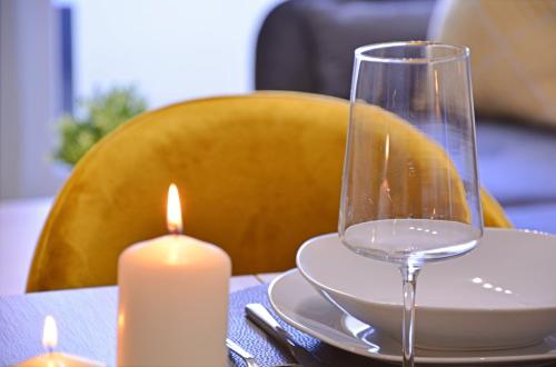 a table with a candle and a wine glass at Sun Towers - Apartamenty Bryza - Apartamenty z parkingiem in Świnoujście