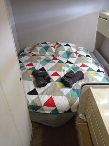 a small bed in a room with a colorful quilt at Un yacht de 24m rien que pour vous ! in Sète