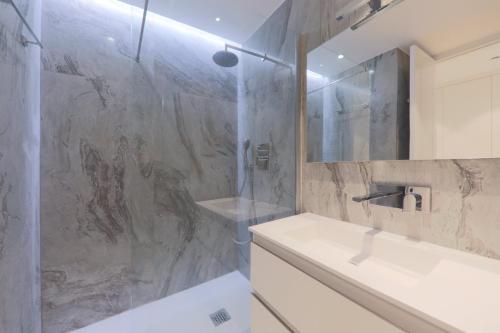 La salle de bains est pourvue d'un lavabo et d'une douche. dans l'établissement CENTER BAY, à Juan-les-Pins