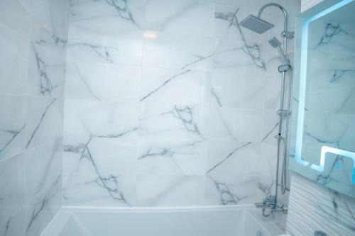 bagno bianco con doccia in marmo bianco di Studio Salin a Turda
