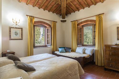 una camera con due letti, un divano e finestre di Casale Giglio a Pergine Valdarno