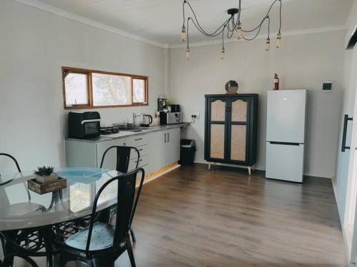 uma cozinha com uma mesa e um frigorífico branco em River Cabin em Roodepoort
