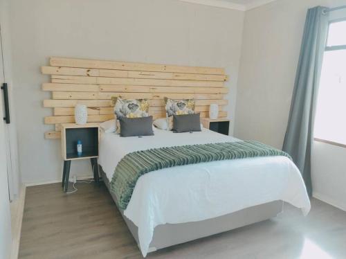 a bedroom with a large bed with a wooden headboard at River Cabin in Roodepoort