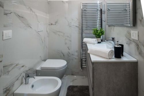 a white bathroom with a toilet and a sink at La Volta - Casa Vacanze in Galatina