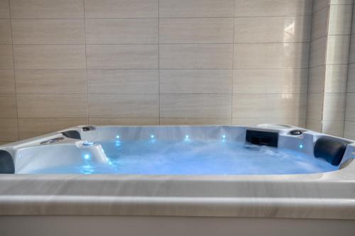 La salle de bains est pourvue d'une baignoire avec de l'eau bleue. dans l'établissement Astron Hotel Rhodes, à Rhodes