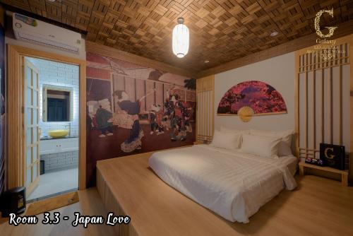 ein Schlafzimmer mit einem Bett und einem Wandgemälde in der Unterkunft Galaxy Hotel 2 in Ho-Chi-Minh-Stadt