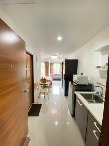 a kitchen with a sink and a table in it at Beach 7 Condo, Pattaya in Jomtien Beach