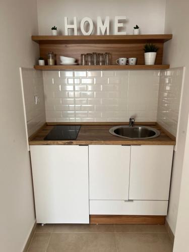 a kitchen with white cabinets and a sink at Apartmani Tesla in Soko Banja