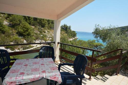 een tafel en stoelen op een veranda met uitzicht op de oceaan bij Holiday home Marina in Sali