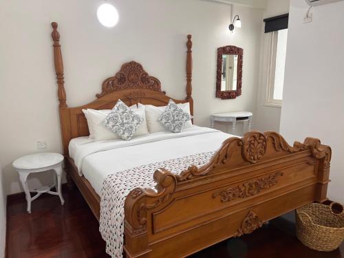 a bedroom with a large bed with a wooden frame at Luï Luï Comfy Condo in Great Location in Kuah
