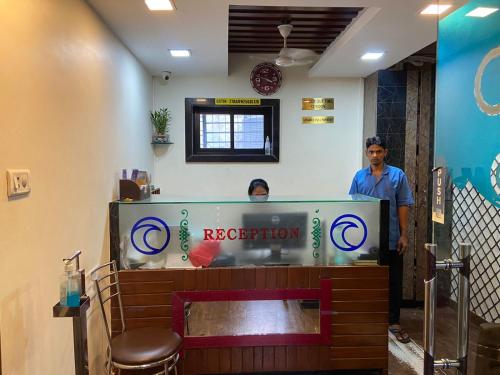 dwóch mężczyzn stojących przy recepcji restauracji w obiekcie Hotel Ocean Residency w Bombaju