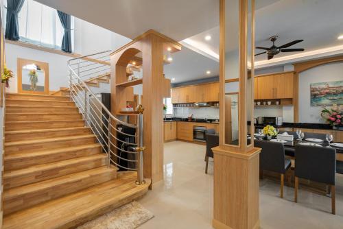 a kitchen and dining room with a staircase in a house at Grand Gala Villa in Pattaya South