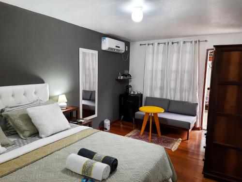 1 dormitorio con cama, sofá y mesa en Agellum Bed & Breakfast, en Domingos Martins