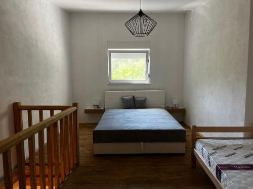 a bedroom with a bed and a window in it at Vila Nomada in Blagaj