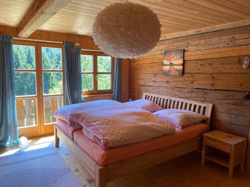 a bedroom with a bed in a room with wooden walls at Ferienhaus Klause in Neureichenau