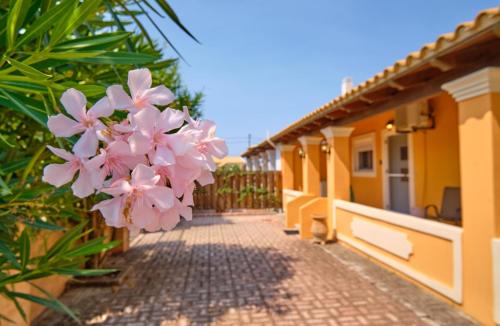 a pathway leading to a house with pink flowers at Drosia Beach House Almyros Corfu in Almiros Beach