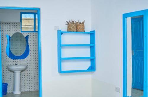 ein Badezimmer mit einem blauen Regal und einem Waschbecken in der Unterkunft Beach House Paje in Paje