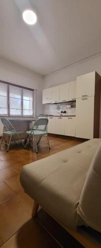 uma sala de estar com um sofá e uma cozinha em A casa di Pintus em Villasimius