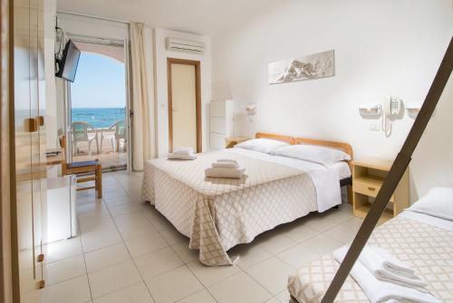 a bedroom with two beds and a view of the ocean at Hotel Continental in Cattolica