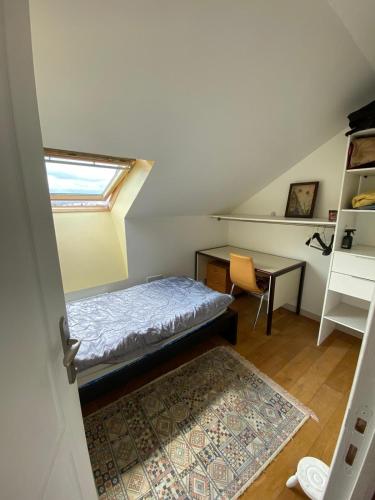 a room with a bed and a desk and a window at CHEZ HUSNA in Conflans-Sainte-Honorine