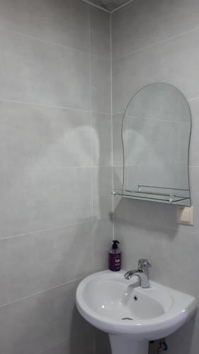 a white bathroom with a sink and a mirror at Guesthouse Angelina-Koko in Sighnaghi