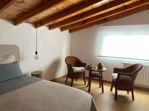 - une chambre avec un lit, des chaises et une table dans l'établissement Acogedora casa en Rinlo, en la villa de Ribadeo, à Ribadeo