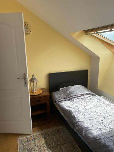 um quarto com uma cama e uma mesa com uma janela em CHEZ HUSNA em Conflans-Sainte-Honorine