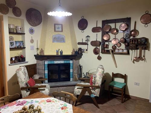 a living room with a fireplace and a table and chairs at Villa Franca in Castelluccio Inferiore