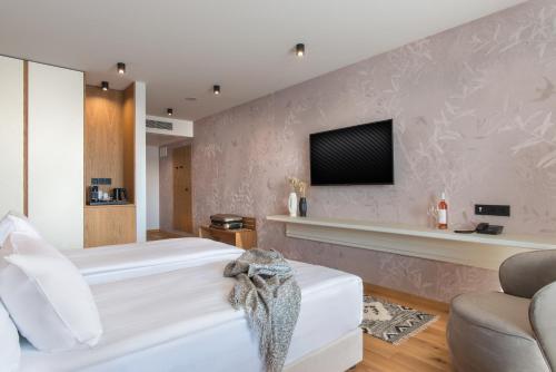 a bedroom with a bed and a tv on a wall at Wine & SPA Hotel Chukara in Tryavna