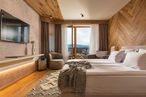 um quarto de hotel com uma cama grande e uma janela em Wine & SPA Hotel Chukara em Tryavna