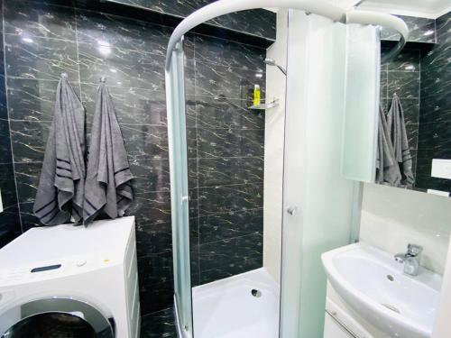 y baño con ducha, aseo y lavamanos. en Central Eco View Apartment, en Chişinău