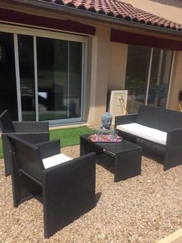 a patio with chairs and a table and a couch at La- ch'tite-Gamassette in Carlucet