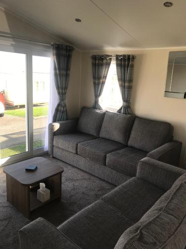 ein Wohnzimmer mit einem Sofa und einem Tisch in der Unterkunft Crimdon dene holiday park in Hartlepool
