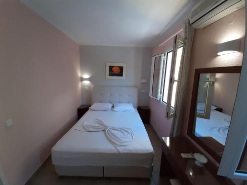 a small room with a bed and a mirror at Amazing apartment in Mpenitses with terrace in Benitses