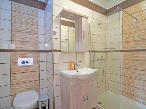 a bathroom with a toilet and a sink and a shower at Alluring apartment in Mpenitses with shared pool in Benitses