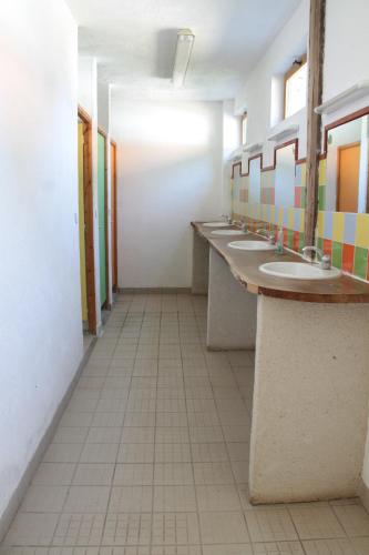 a bathroom with a row of sinks and mirrors at Chez Tombivouac in Pierrefonds