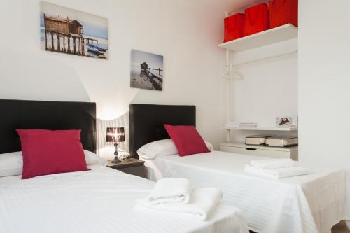 バルセロナにあるKey San Pau House Terrace - Barcelonaの赤い枕付きのベッド2台が備わる客室です。