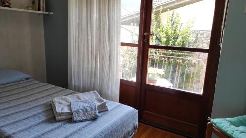 um quarto com uma cama e uma porta com uma janela em Casabella Silvana em Aosta
