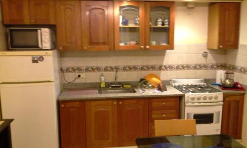 uma cozinha com armários de madeira e um forno de fogão branco em Residencia "Libertad" em San Andrés