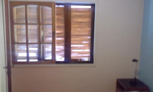 uma janela com persianas de madeira num quarto em Residencia "Libertad" em San Andrés