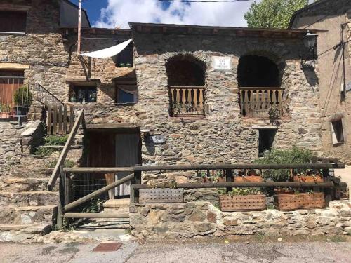 Um velho edifício de pedra com abóboras à frente. em Charming Stone House in the Pre-Pyrennes em Ribes de Freser