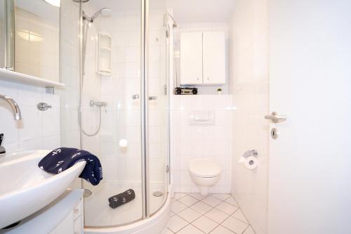 ein Bad mit einer Dusche, einem Waschbecken und einem WC in der Unterkunft Haus Atlantic Whg "Ferijentied" in Grömitz