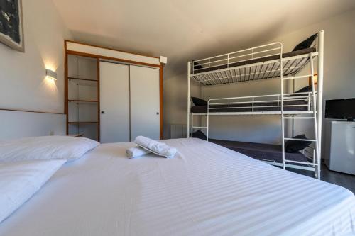 a bedroom with a bed with two bunk beds at La Jalousie in Saint-Aignan-de-Cramesnil