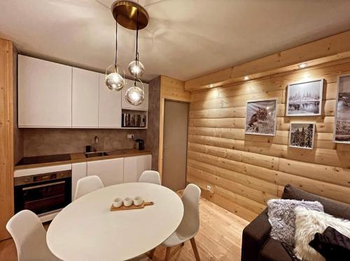 eine Küche und ein Esszimmer mit einem weißen Tisch und Stühlen in der Unterkunft LeChalet N22 Au pied des pistes in Saint-Lary-Soulan