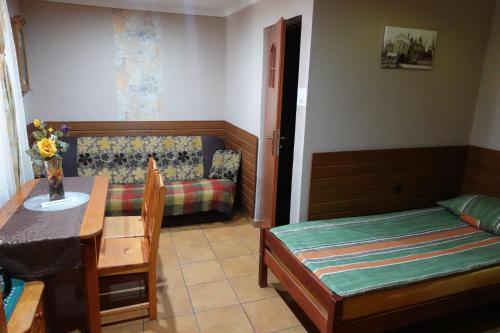 Habitación con 1 dormitorio con 1 cama y 1 mesa. en Noclegi u Ani en Opatów