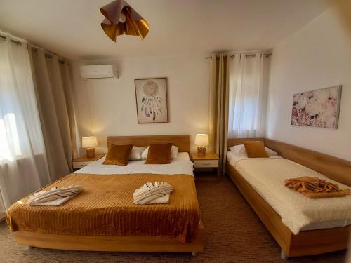 um quarto de hotel com duas camas e duas lâmpadas em Studio Apartmani “Jarnečić” em Krk