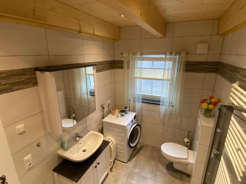 a bathroom with a sink and a washing machine at Ferienwohnung Leimitz in Hof