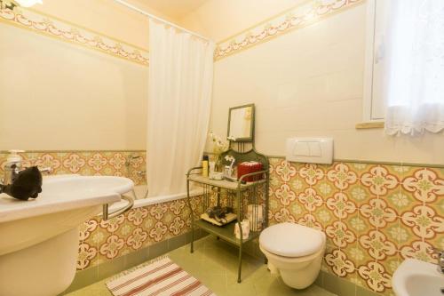 a bathroom with a white toilet and a sink at Villa Monserrato - Goelba in Porto Azzurro