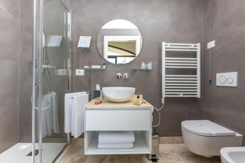 een badkamer met een wastafel, een toilet en een spiegel bij Locanda da Toto in Genua